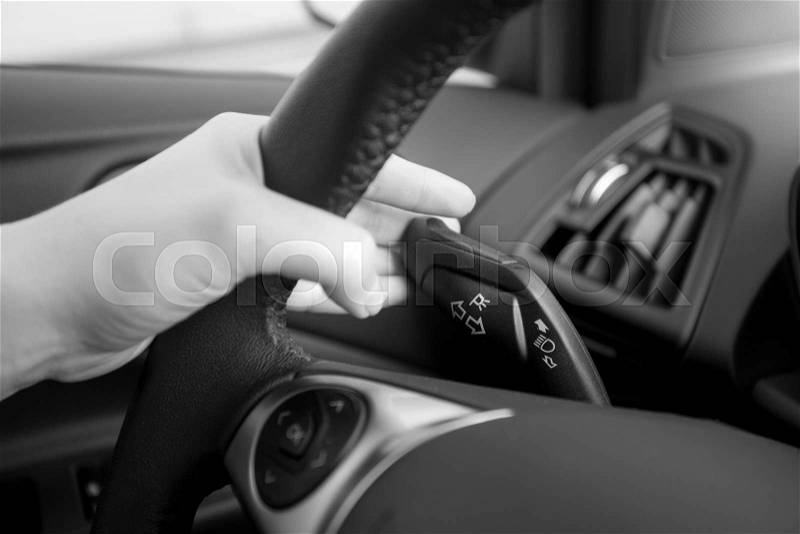 Closeup black and white photo of driver using turn signal, stock photo