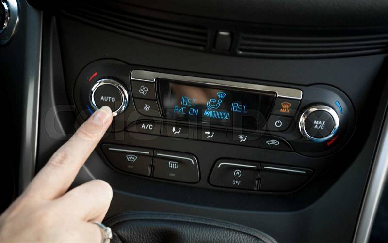 Closeup photo of woman adjusting temperature on car climate control system, stock photo