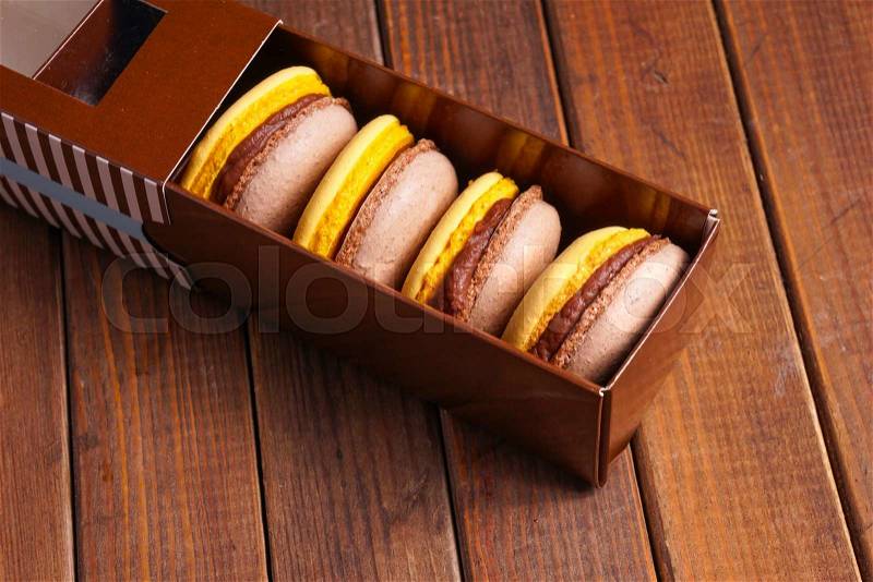 Macaroons cakes in box. delicious beige and yellow macaroon, stock photo