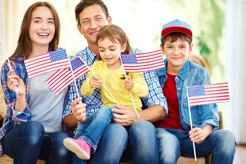 Happy family with flags of USA celebrating Independence Day, stock photo