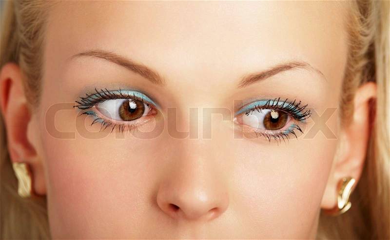 A beautiful blonde face with huge brown eyes close-up, stock photo