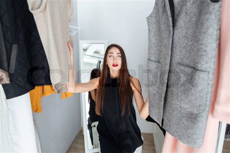 Beautiful woman choosing cloth in boutique, stock photo