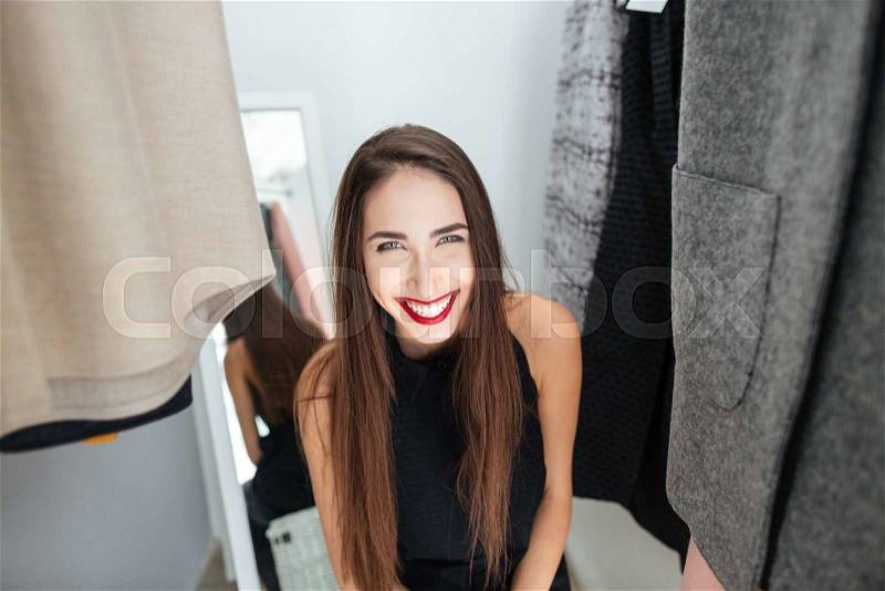 Laughing woman standing in dressing room , stock photo