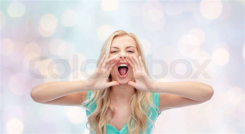 Emotions, expressions and people concept - angry young woman or teenage girl shouting over holidays lights background, stock photo