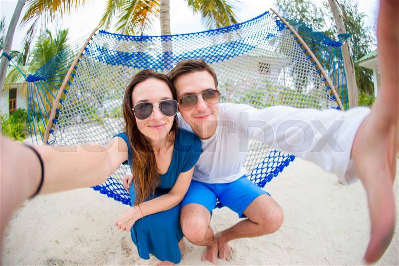 Young loving couple in a hammock in exotic resort, stock photo
