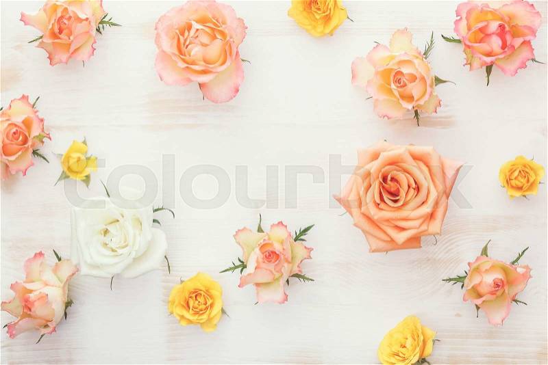 Rose flower background. Natural rose flowers on rustic background with space for text in the middle. Top view, vintage toned image, stock photo