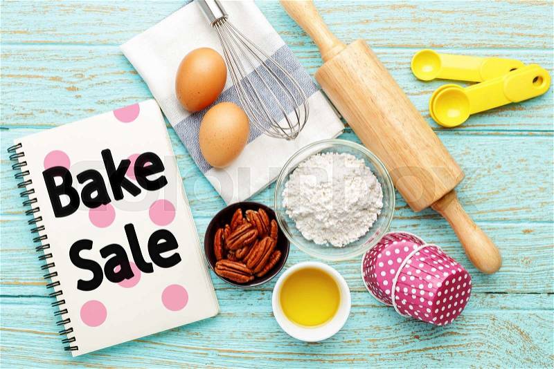 Bake sale with baking ingredients on wood table, stock photo
