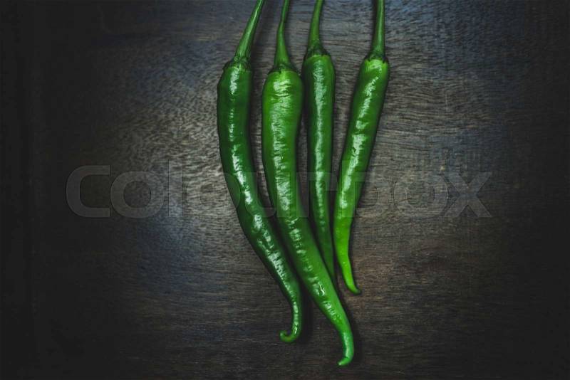 Close up hot peppers spices on black wooden table, stock photo