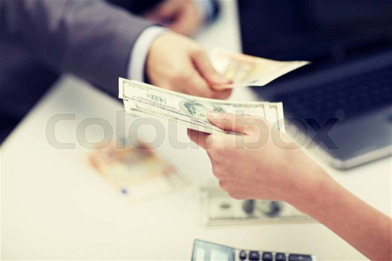 Finances, currency, exchange rate, business and people concept - close up of male and female hands giving or exchanging money at office, stock photo