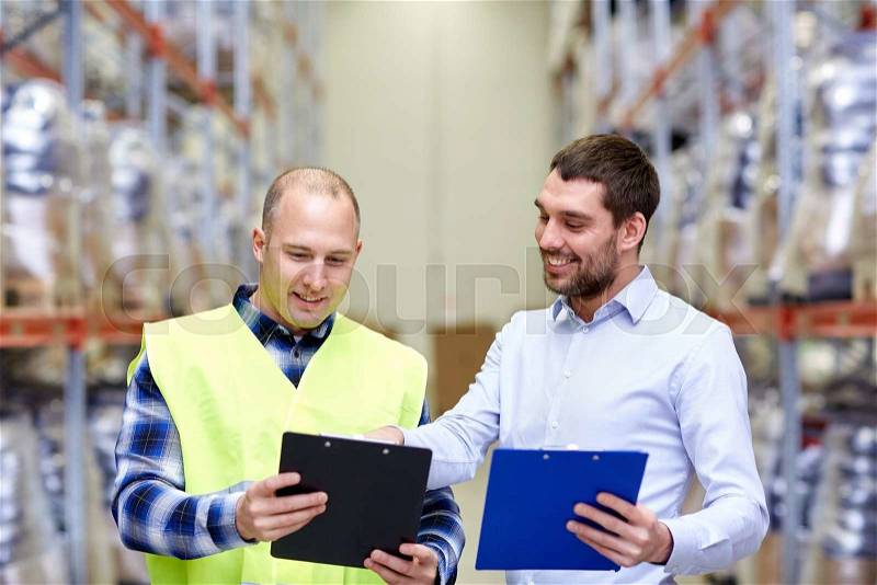 Wholesale, logistic, people and export concept - manual worker and businessmen with clipboards at warehouse, stock photo