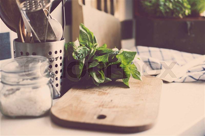 A bunch of basil on the board on the kitchen table, home kitchen supplies for cooking, stock photo