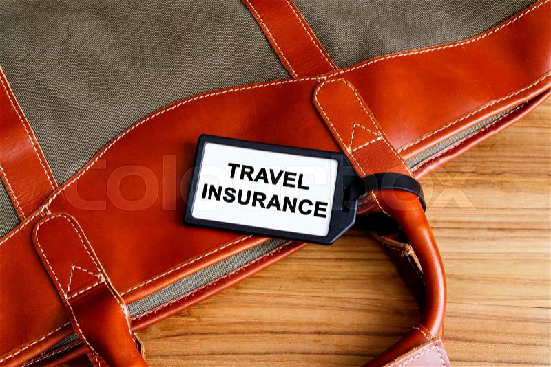 Travel insurance tag on travel bag, stock photo