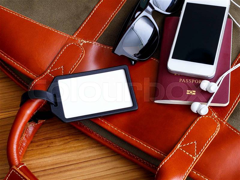 Travel bag and blank tag with phone and sunglasses for tourism concept, stock photo