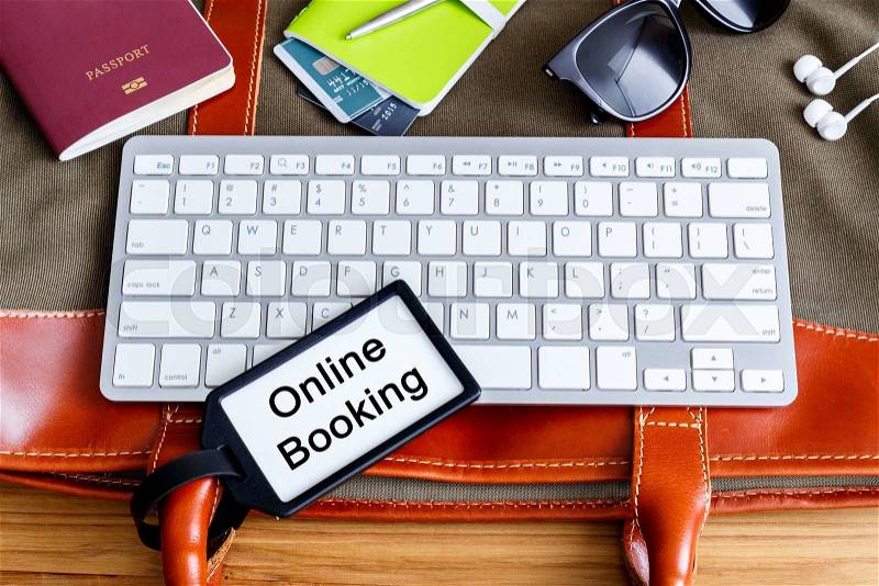 Online travel booking and planning concept with bag tag and traveling accessories, stock photo