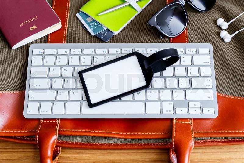 Travel booking and planning concept with blank bag tag and traveling accessories, stock photo