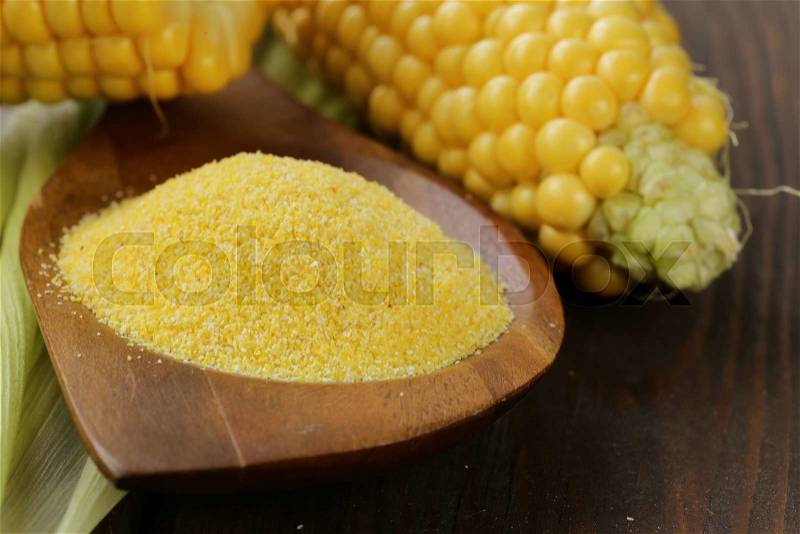 Natural organic corn grits and cobs on the wooden table, stock photo