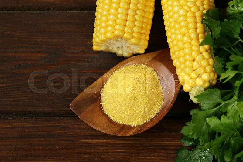 Natural organic corn grits and cobs on the wooden table, stock photo
