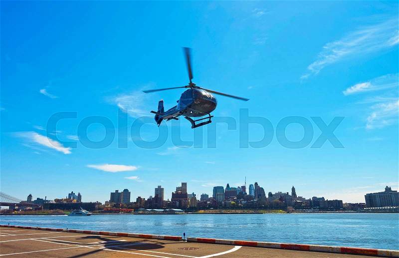 Black Helicopter taking off from helipad in Lower Manhattan in New York, USA, on East River. Pier 6. East River and skyscrapers of Brooklyn on the background, stock photo