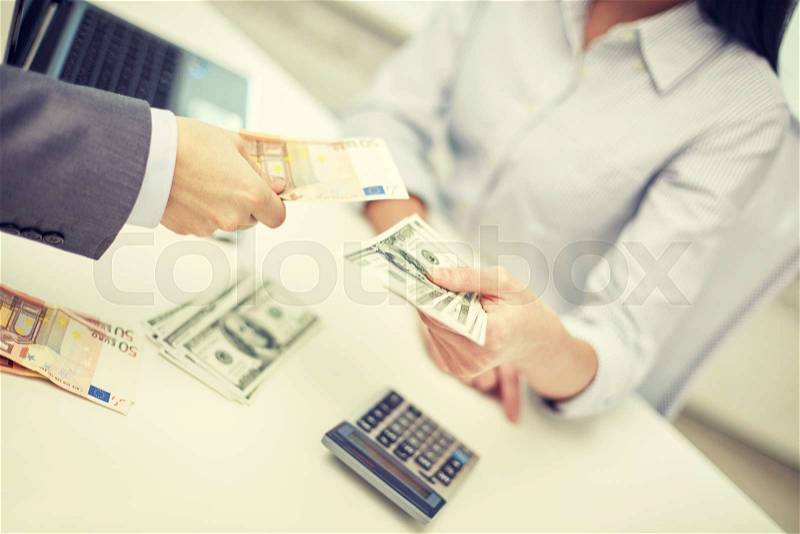 Finances, currency, exchange rate, business and people concept - close up of male and female hands giving or exchanging money at office, stock photo