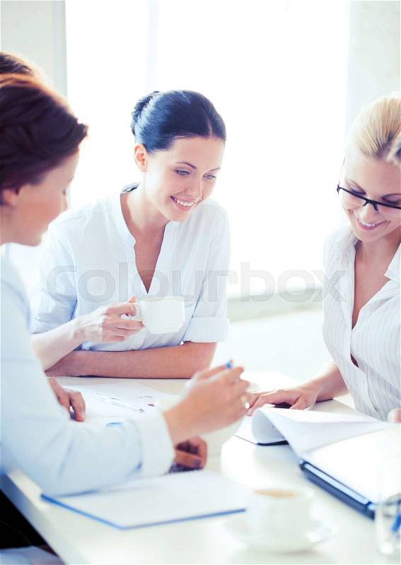 Smiling businesswoman with team on meeting in office, stock photo
