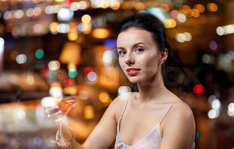 People, party, nightlife, drink and holidays concept - glamorous woman with cocktail at night club or bar, stock photo