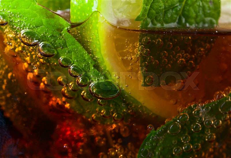 cocktail Cuba libre with lime , ice and peppermint leaves , stock photo