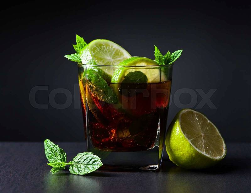 cocktail Cuba libre with lime , ice and peppermint leaves , stock photo