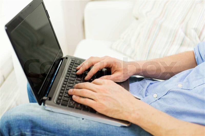 Technology, people and lifestyle concept - close up of male hands typing on laptop computer keyboard at home, stock photo