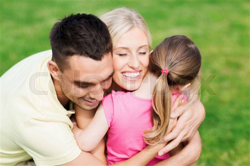 Family, happiness, adoption and people concept - happy family hugging outdoors, stock photo
