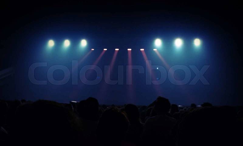 Abstract entertainment event background. Blurred photo with spotlights scene illumination. Spectators watch the stage, stock photo