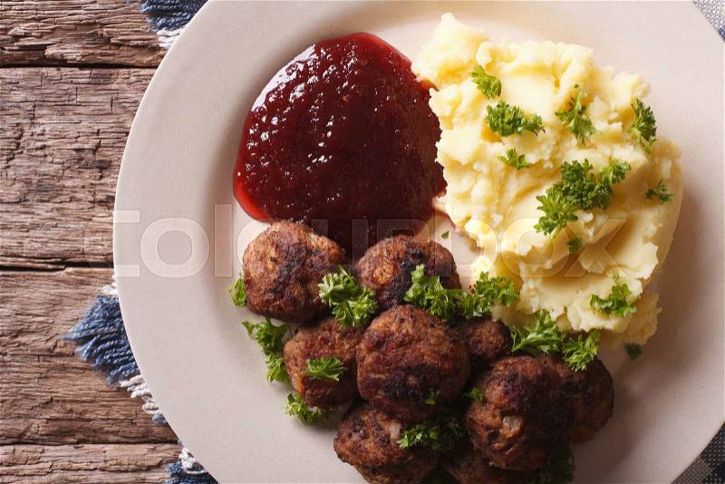 Swedish cuisine: meatballs, lingonberry sauce with potato garnish on a plate close-up. horizontal view from above , stock photo
