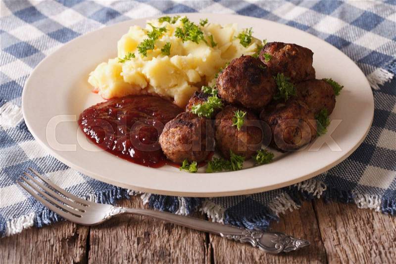 Swedish cuisine: meatballs, lingonberry sauce with potato garnish on a plate close-up. horizontal , stock photo