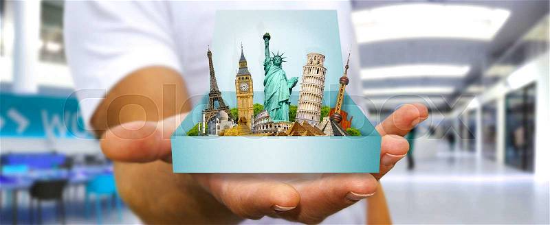 Young man holding travel box in his hand containing famous monuments of the world, stock photo
