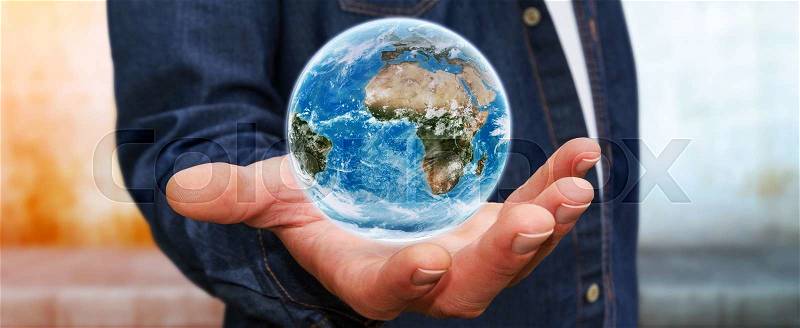 Young man holding the blue planet earth in his hand, stock photo