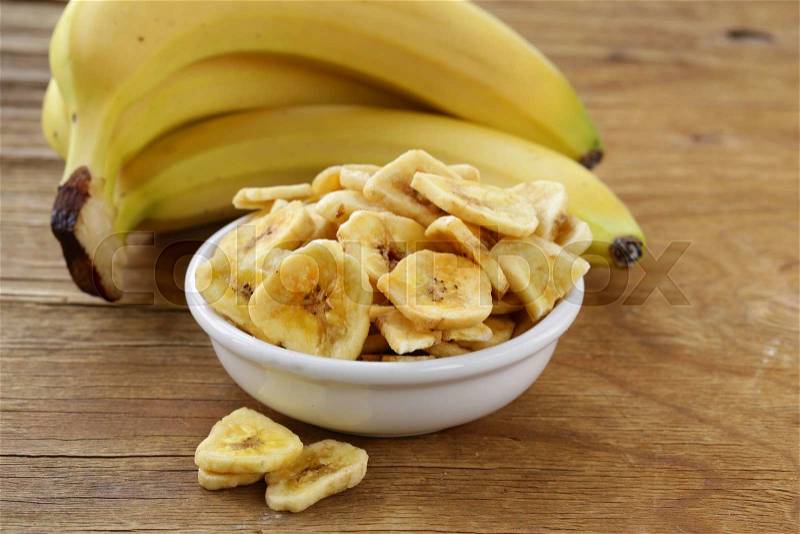 Banana chips, dried fruit on a wooden table, stock photo
