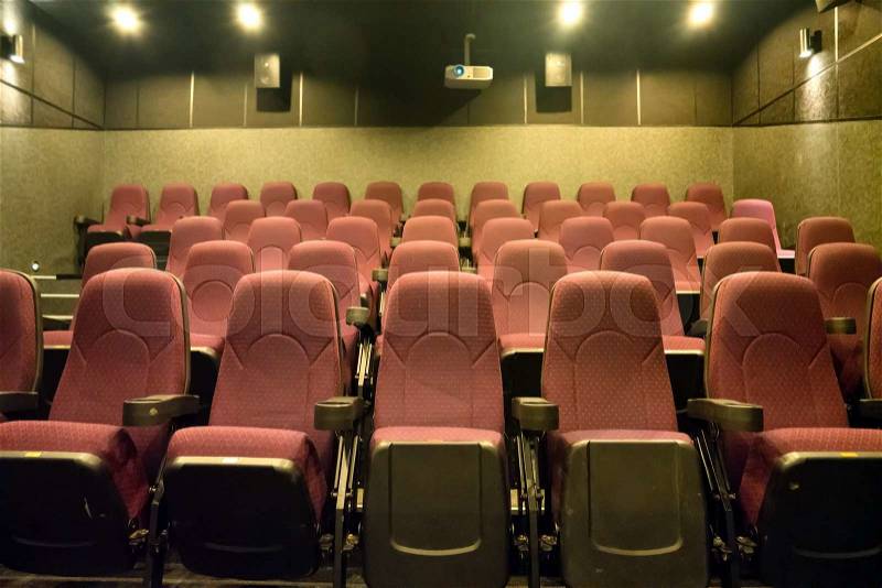 Empty seats in the small movie theater with cinema projector, stock photo