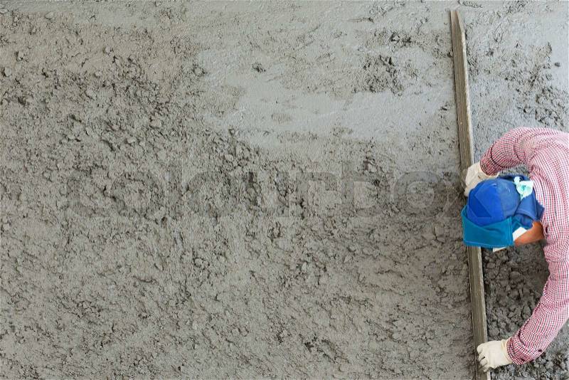 Plasterer concrete cement worker plastering flooring of house construction, stock photo