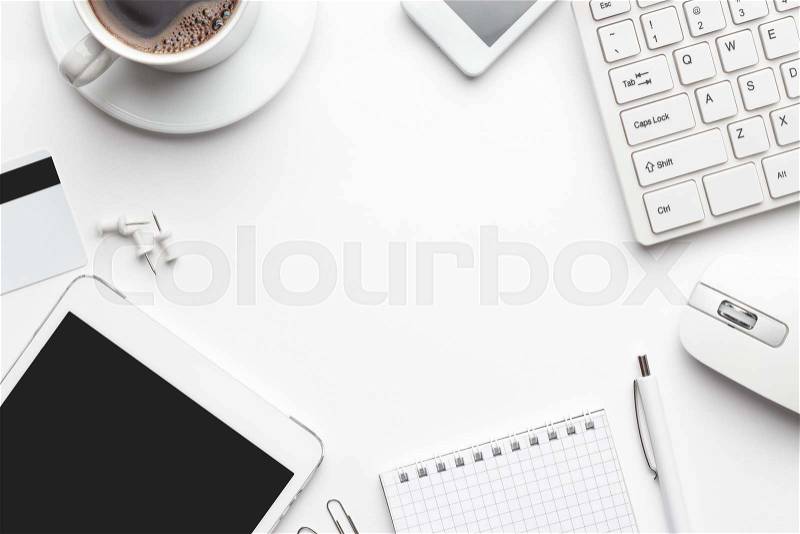 Overhead of white office table with notebook, computer keyboard and mouse, tablet pc and smartphone. copy space, stock photo