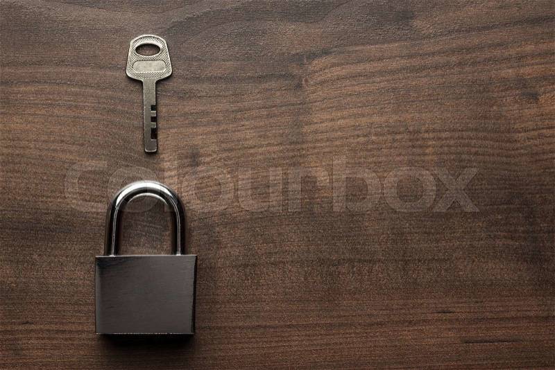 Check-lock and key on the brown wooden table background, stock photo