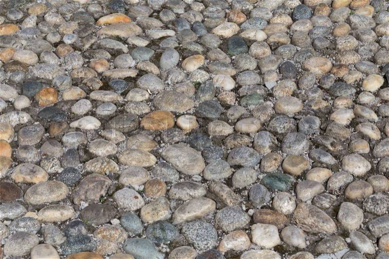 Round stones in the ground. Texture of the cobblestones in Park. Paved road for pedestrians. The paving stones. Background, stock photo