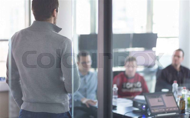 Business man making a presentation at office. Business executive delivering a presentation to his colleagues during meeting or in-house business training, explaining business plans to his employees. , stock photo
