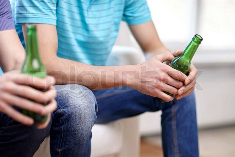 Leisure, people and alcohol concept - close up of male friends drinking beer at home, stock photo
