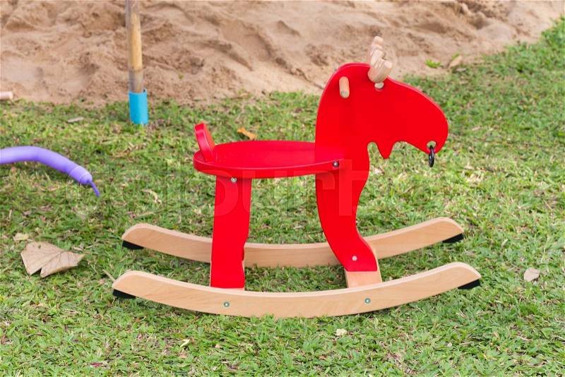 Rocking deer chair for kids ride playing in playground, stock photo