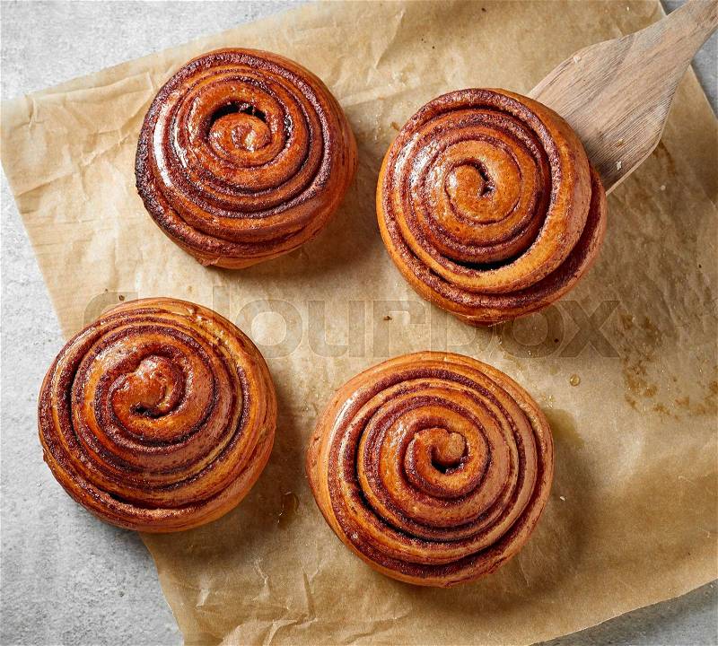 Freshly baked sweet cinnamon buns on kitchen table, top view, stock photo