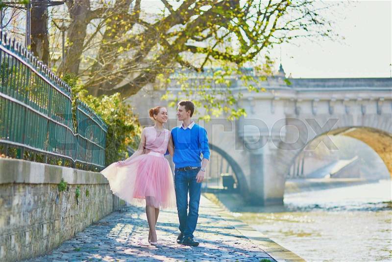 Beautiful romantic couple in Paris near the river Seine, walking together, stock photo