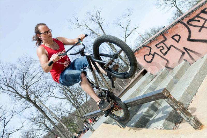 BMX rider balancing on his front tire. , stock photo