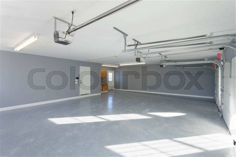 Beautiful brand new three car garage interior with finished floors and work space, stock photo