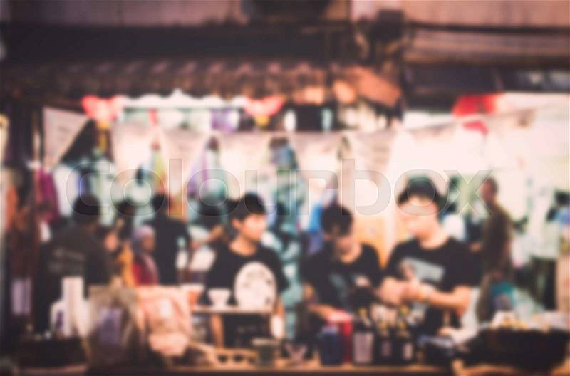 Blurred people buying food on the street at night for background, stock photo
