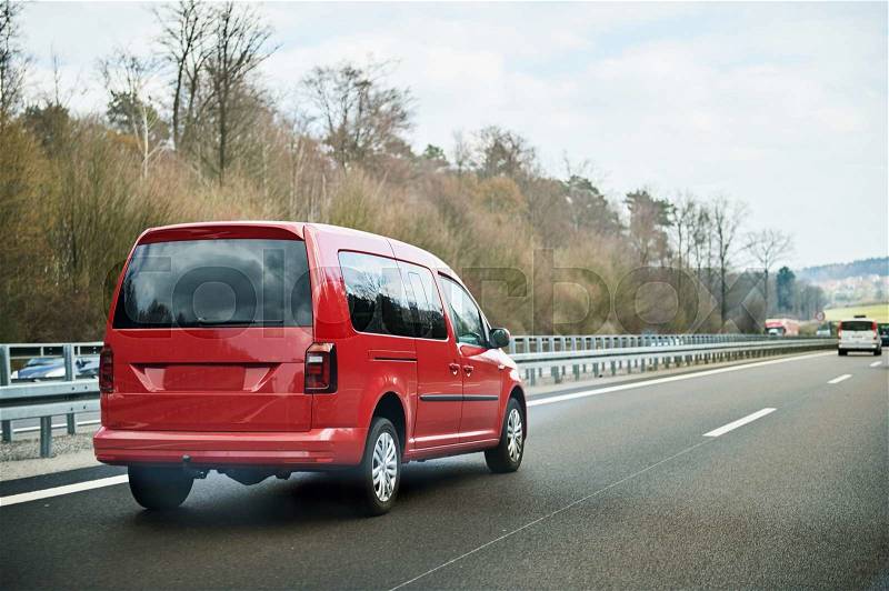 Fast red mini van on highway autobahn on a spring day, stock photo