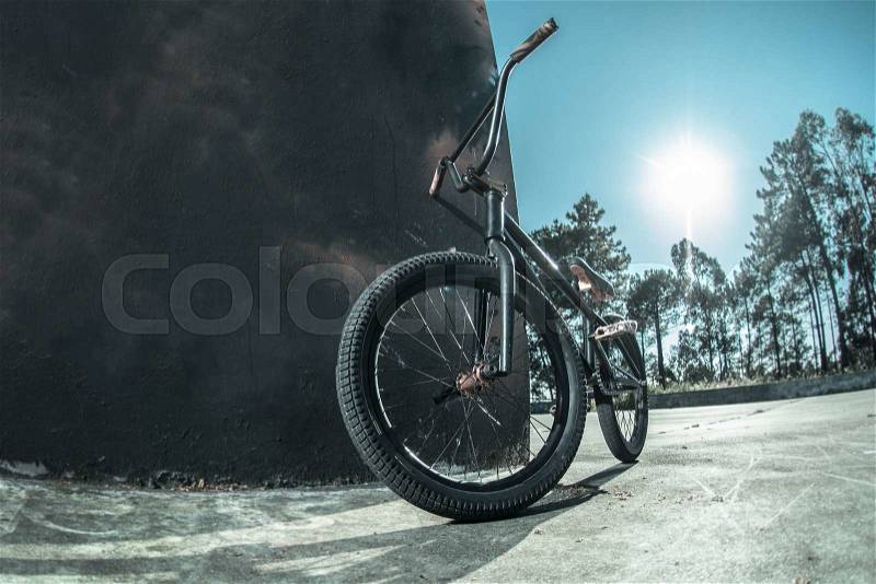 Bmx bike standing against black rough painted wall, stock photo
